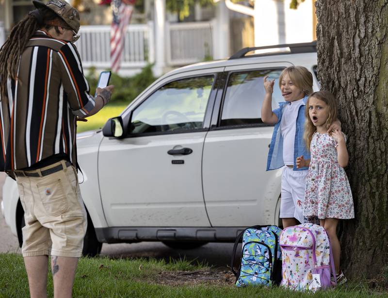 Robert Bradley snaps a picture of son Robert, 6, and daughter Octavia, 5, Wednesday, Aug. 13, 2025, outside of Washington School. Dixon students had their first day of the 2025-26 school year.