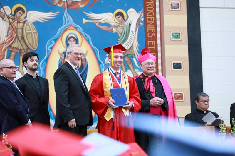 Marian Central Catholic High School Salutatorian Patrick Kumm poses Friday, May 27, 2022, with his diploma and Rev. Charles Warren, Superintendent Michael Shukis and the Most Rev. David Malloy.