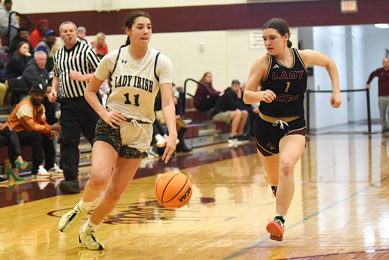 Bishop McNamara's Trinity Davis, left, dribbles past Mt. Carmel's Alivia Peach during the IHSA Class 2A Tolono Unity Super-Sectional Monday, March 3, 2025.