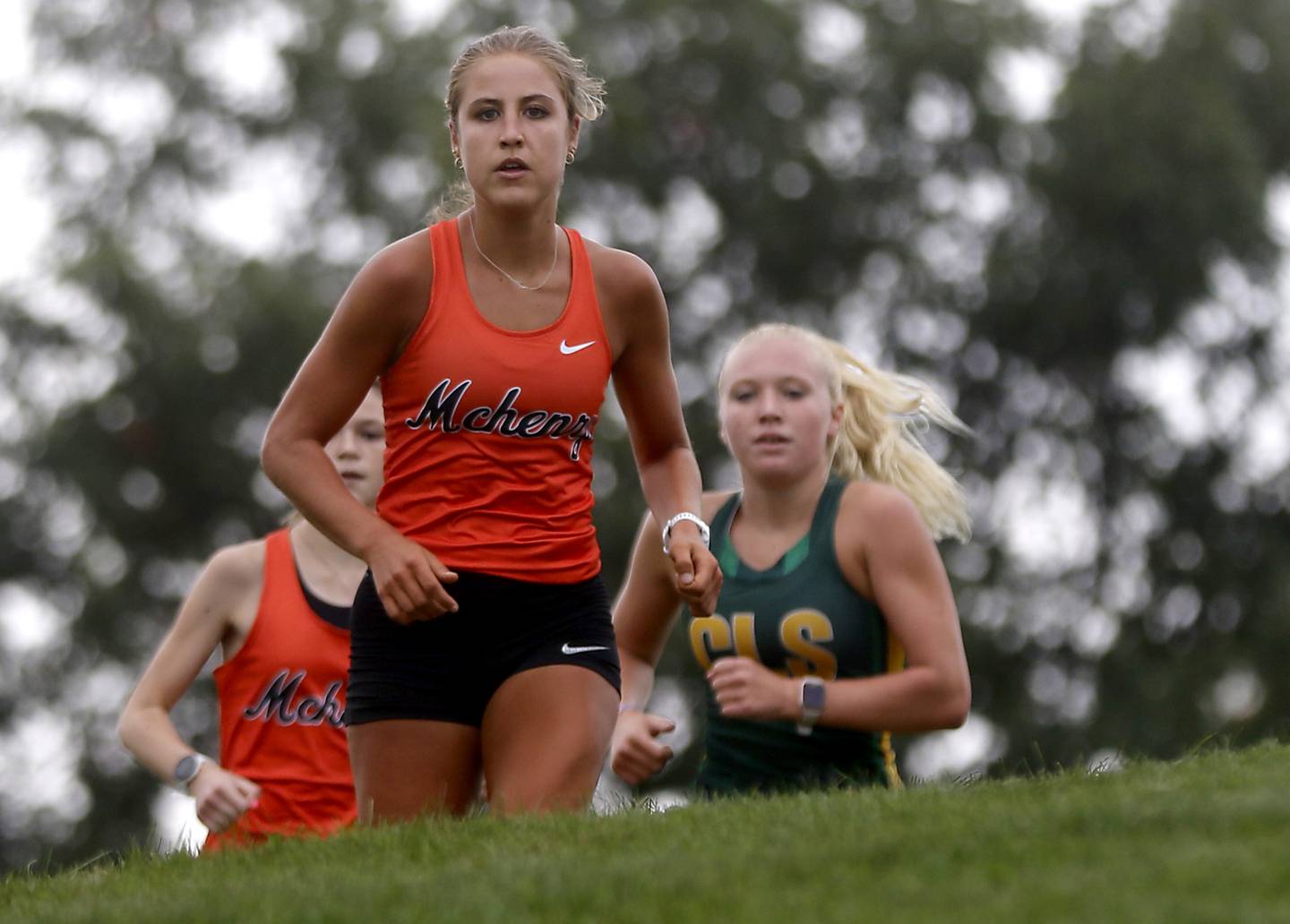 McHenry’s Danielle Jensen (center) leads the girls race of the McHenry County Cross Country Meet in front of her teammate, Skyler Balzer, and Crystal Lake South’s Abby Machesky on Saturday, August 27, 2022, at Emricson Park in Woodstock.