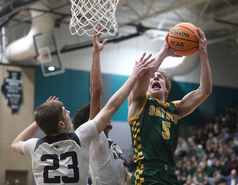 Crystal Lake South's Carson Trivellini (right) drives to the basket agaisnt Kaneland's Connor Kimme (left) and Evan Frieders (center) during the IHSA Class 3A Woodstock North Sectional final basketball game on Friday, March 6, 2026, at Woodstock North High School.