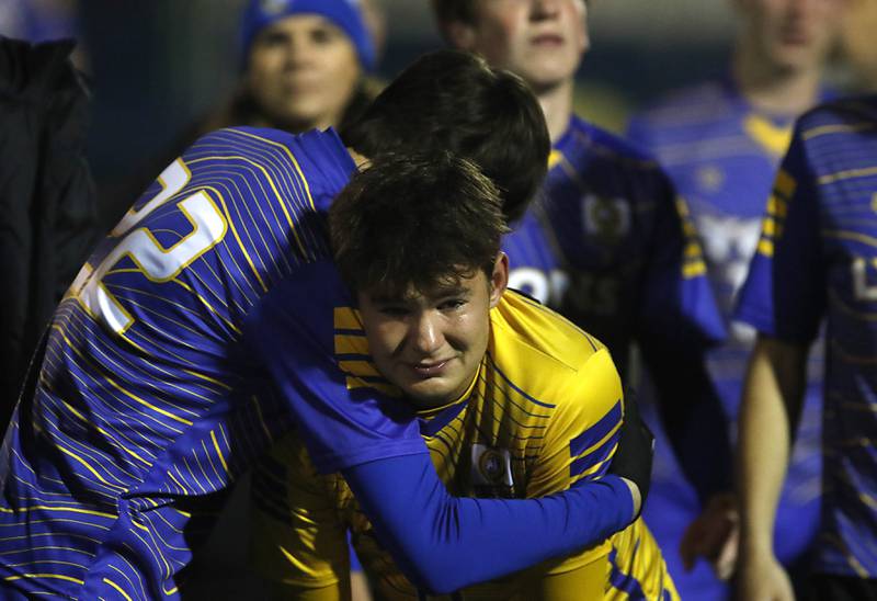 Lyons Township's Filip Soldat hugs goalkeeper Tyler Balon after Lyons Township was defeated by New Trier in the IHSA Class 3A state championship soccer match on Saturday, Nov. 4, 2023, at Hoffman Estates High School.