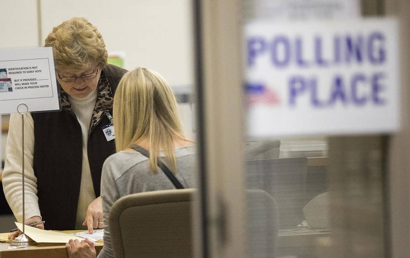 Election judge Sharon Holmes helps a voter Thursday at the DeKalb County Legislative Center in Sycamore.
