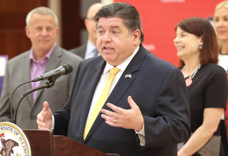 Gov. JB Pritzker, speaks as DeKalb Mayor Cohen Barnes and Northern Illinois University President Lisa Freeman look on during a news conference Tuesday, April, 4, 2023, in the Barsema Alumni and Visitors Center at NIU in DeKalb. Pritzker along with a group of llinois lawmakers, DeKalb city officials and representatives from NIU were on hand to promote the importance of funding higher education in Illinois.