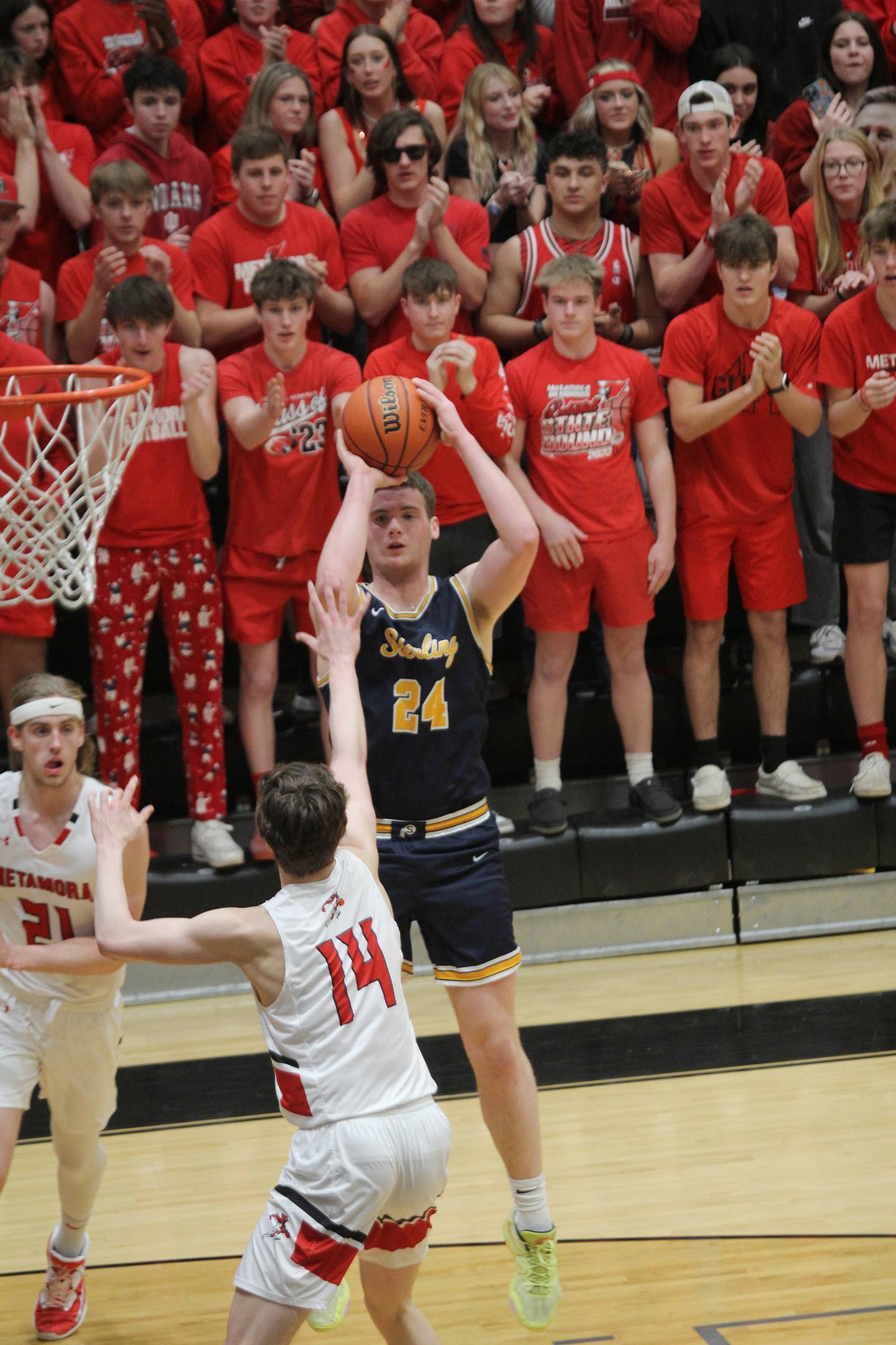 Sterling's Lucas Austin (24) shoots over Metamora's Luke Hopp as the Metamora student section looks on during the first half of their Class 3A Galesburg Sectional semifinal on Wednesday, March 1, 2023.
