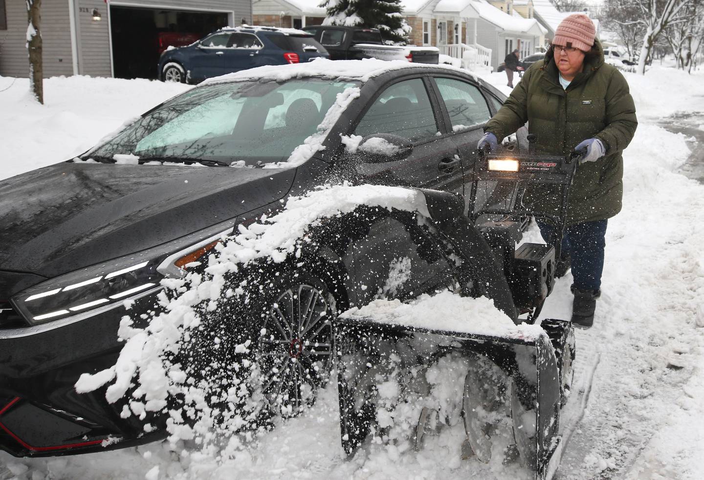 Rhonda Cioni, from DeKalb, helps her neighbor dig his car out Friday, Jan. 12, 2024, after early morning snow covered his vehicle. Several inches of snow blanketed DeKalb County Friday on top of the 6 inches that fell on the area earlier this week.