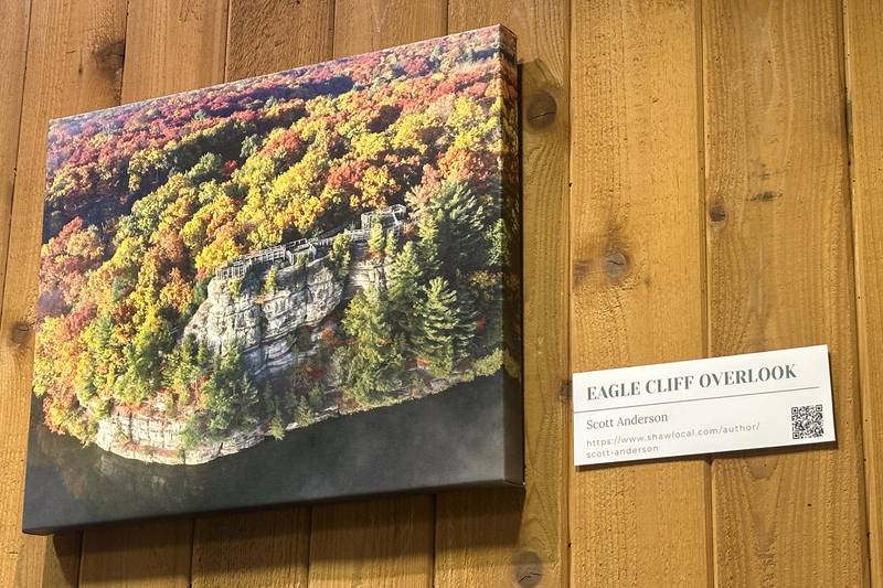 A view of the Eagle Cliff photo taken by Shaw Local photo editor Scott Anderson hangs on the wall on Sunday, May 3, 2026 at the Starved Rock Visitors Center. The Starved Rock Fondation featured Anderson's photo on the cover of the 2026 calendar.