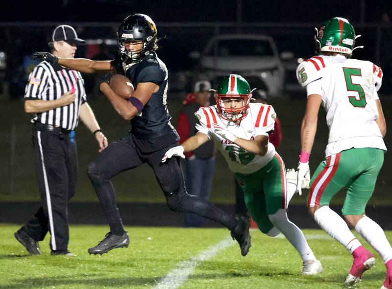 Sycamore's Dylan Curtis crosses the goalline for a touchdown just ahead of La Salle-Peru's Evan Downey (left) and Regan Doerr during their game Friday, Oct. 10, 2025, at Sycamore High School.