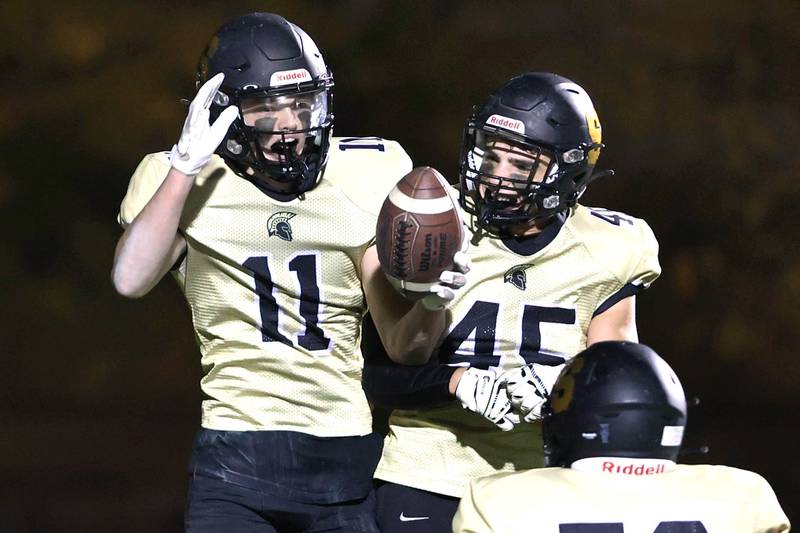 Sycamore's Burke Gautcher (left) and Kaden Ladas celebrate Gautcher's touchdown during their game against Woodstock North Friday Oct. 7, 2022, at Sycamore High School.