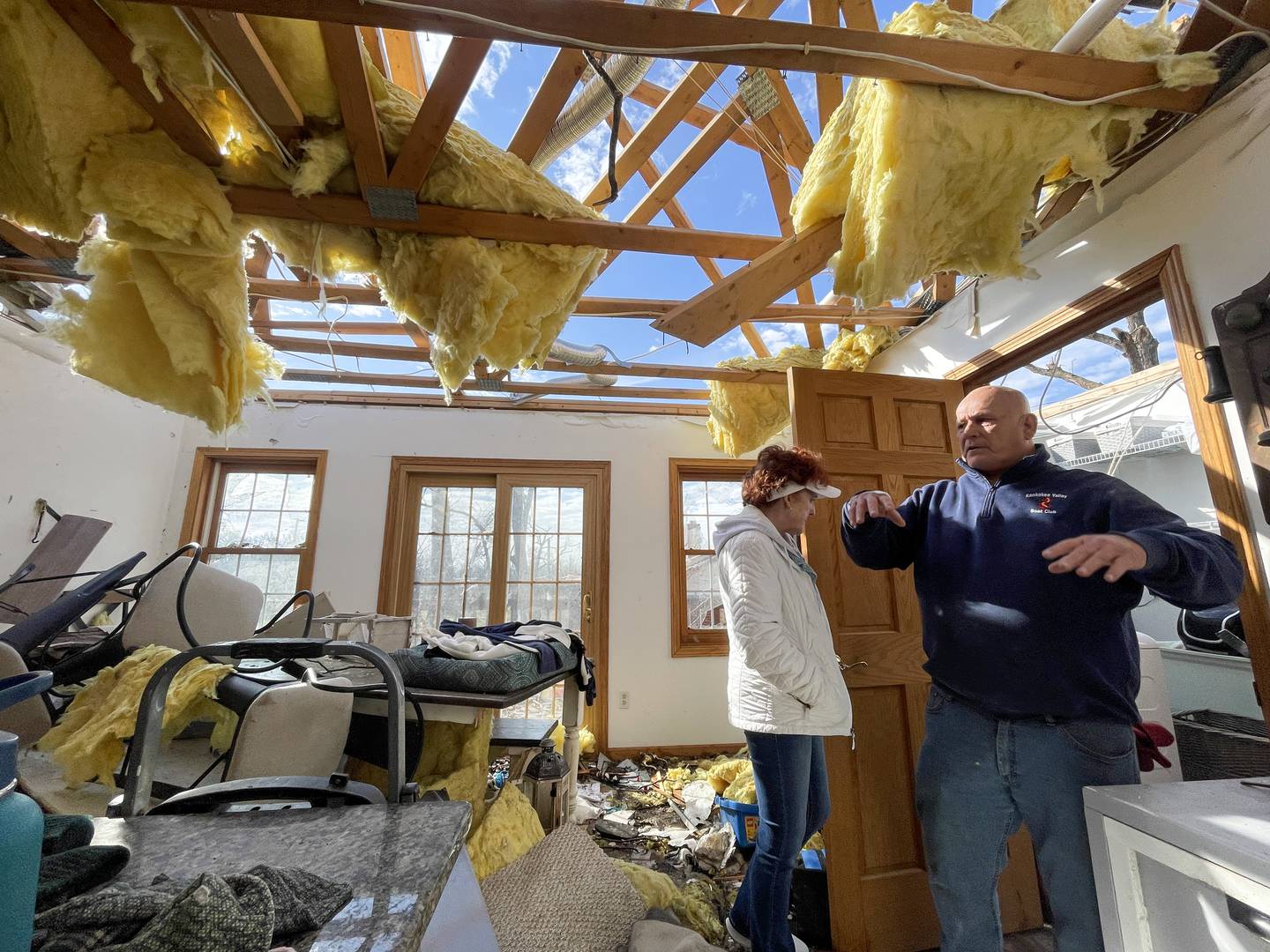 Aroma Township resident Tim Pinson describes the sound of the March 10 tornado passing overhead his home on Elmwood Drive on March 19, 2026, from his former kitchen. Pinson and his wife, Karen, left, took shelter in a closet in the next room.
