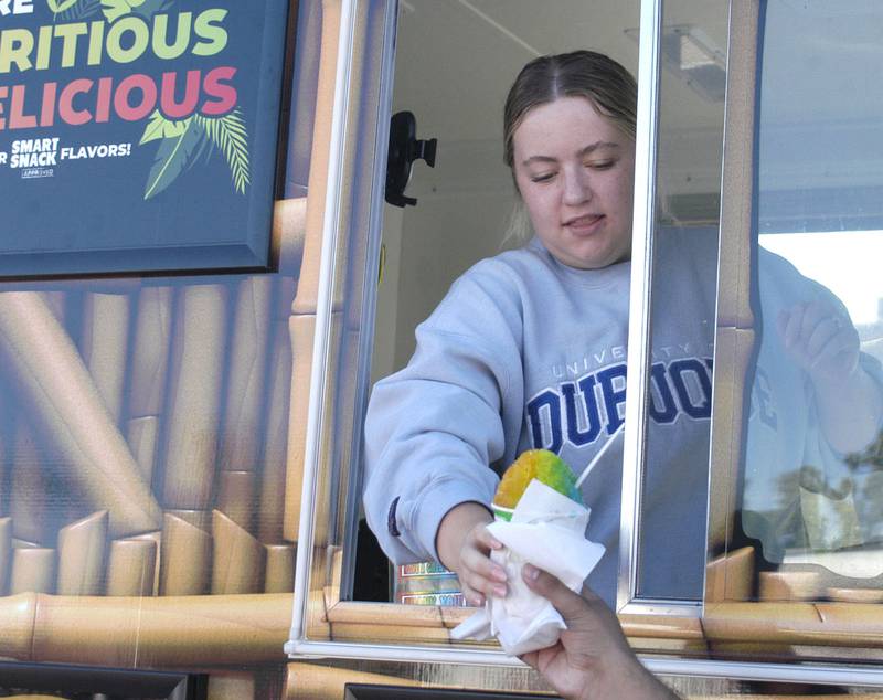 Chole Coil of Dixon hands out Kona Ice in a downtown parking lot during Halloween Town. The Craft Beer Festival and Halloween Town offered fun for all in downtown Sterling The events took place on Saturday, October 11th, 2025.