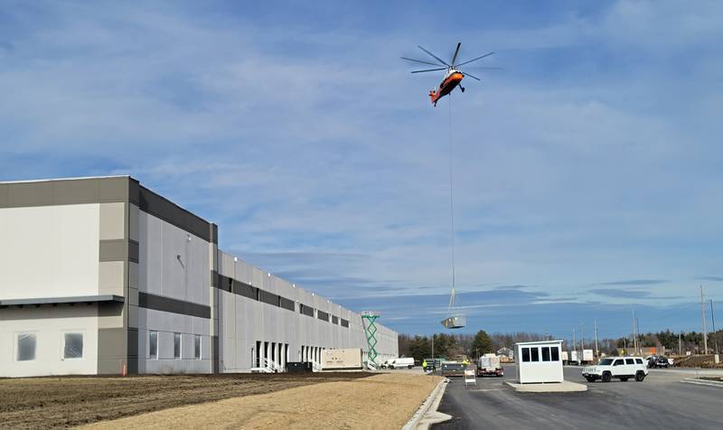 A 1962 Sikorsky helicopter lifts one of 10 heating and air conditioning units onto the roof of the new Ollie’s Bargain Outlet warehouse near the intersection of Interstate 80 and Illinois Route 26 in Princeton on Friday morning. The helicopter, according to an employee of Midwest Helicopters in Willowbrook, has a maximum lifting capacity of 5,000 pounds, so it managed to handle with ease the units that ranged in weight from 1,000 to 2,500 pounds in less than half an hour.