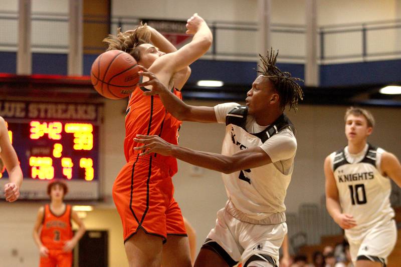 McHenry’s Adam Bronowicki, left, defends as Kaneland’s Isaiah Gipson passes the ball under the net in Hoops for Healing basketball tournament championship game action at Woodstock Wednesday.