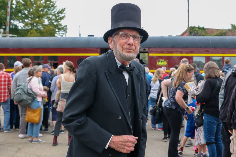 Vernon Risty (Abraham Lincoln impersonator) poses for picture in front of train on Saturday, September 28, 2024 at the railroad tracks in Bureau.
