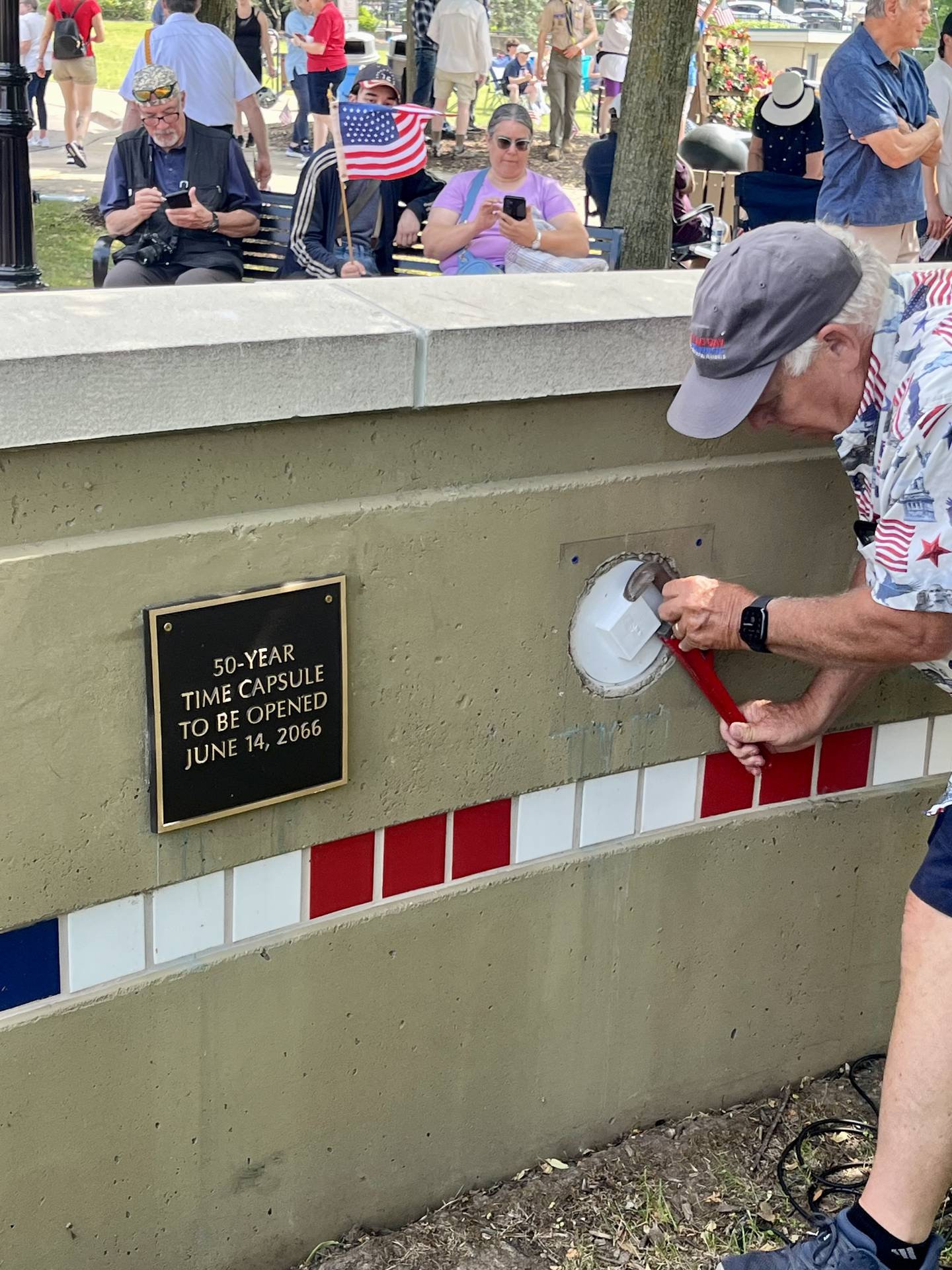 Workers turn the final screws of the wrench sealing two 50-year time capsules for future Batavians to open at the town's Flag Day Monument memorial wall.