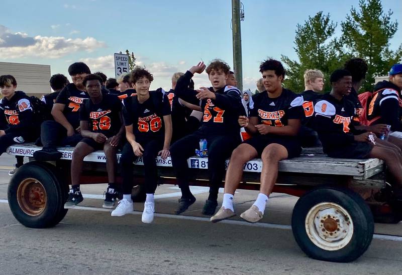 DeKalb Barbs football players throw candy as the crowd awaits during the annual DeKalb High School Homecoming Parade on Wednesday, Sept. 24, 2025, along West Dresser Road.