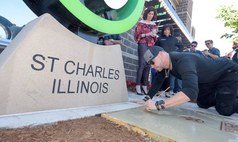 Donnie Wahlberg signs his name an places a hand print in wet cement during the Wahlk of Fame Ceremony for New Kids on the Block at the Wahlburgers in St. Charles on Saturday, June 18, 2022.