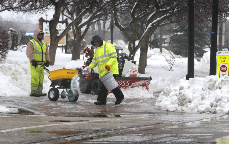 Workers from Ringers Landscape Services,  treat sidewalks near the Downtown Crystal Lake Metra station on Tuesday, Jan. 23, 2023. Residents throughout northern Illinois woke up to icy and slippery roads.