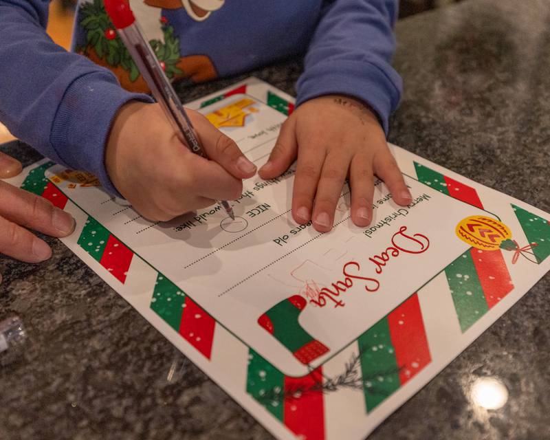 Levi Pyszka marks 'Nice' on letter to Santa at the annual Christmas in the Valley on Saturday, November 15, 2025 at the Tee Box in Spring Valley.