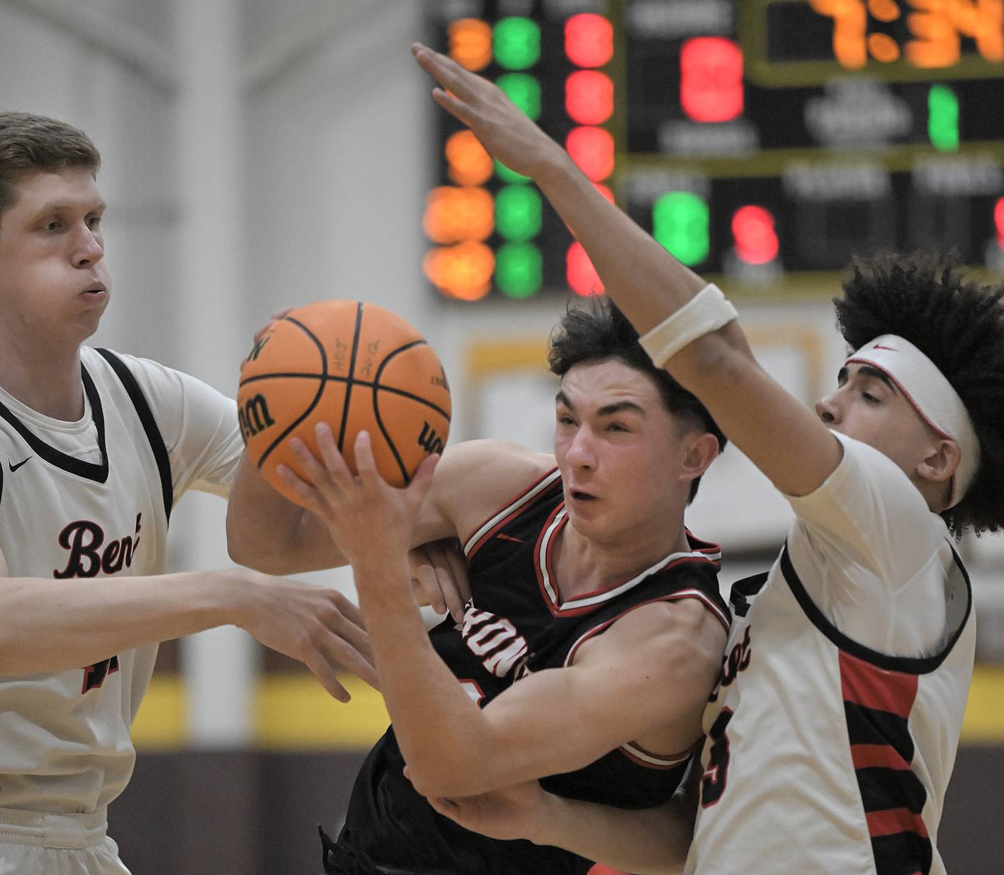 Barrington’s Jackson Roberts is fouled as he tries to go between Benet’s Colin Stack and Jayden Wright, right, in a boys basketball game at the Jacobs Hinkle Classic semifinals in Algonquin on Tuesday, Dec. 23, 2025.