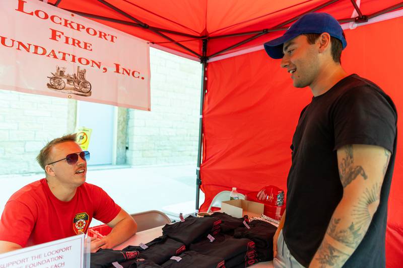 Jack Irwin, of Lockport Township Fire Protection District, chats with Lockport resident Frank Jilek at the Lockport Fire Foundation booth during Fire Fest on August 10, 2024.