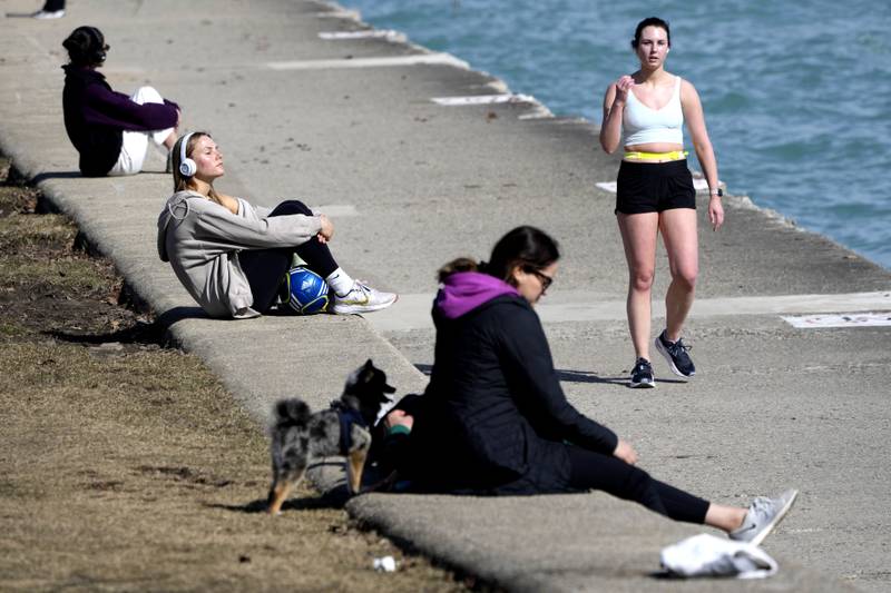 Pedestrians take in the warmer than normal temperatures near the North Avenue Beach Pier along Lake Michigan on Feb. 26 in Chicago.