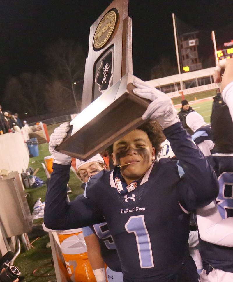 DePaul's Jett Reese hoists the Class 4A State football championship trophy on Friday, Nov. 29, 2024 at Hancock Stadium in Normal.