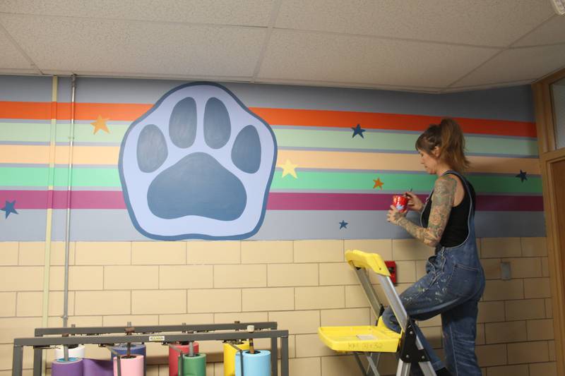 Parent Sara Jean Stevens adds some finishing touches to one of the murals she painted at District 47's North Elementary School in Crystal Lake.