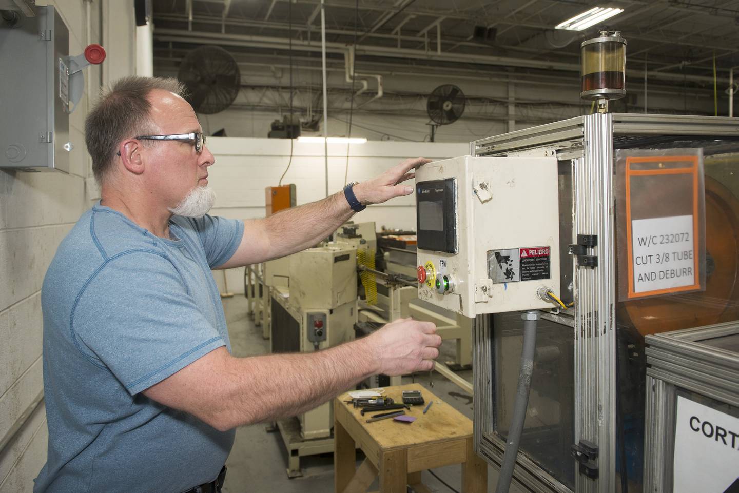 Engineer Bob Sawyer runs a machine at the plant Wednesday, March 23, 2022. This machine straightens and cuts tubes for the power steering cooler.