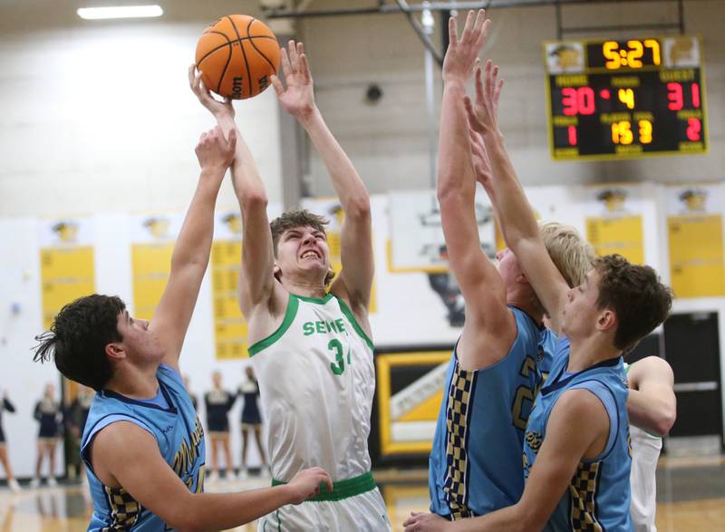 Seneca's Patrick Griffin lets go of the ball under the hoop as Marquette's Matt Graham, Luike McCullough and Lucas Craig defend during the Tri-County Conference championship on Friday, Jan. 31, 2025 at Putnam County High School.