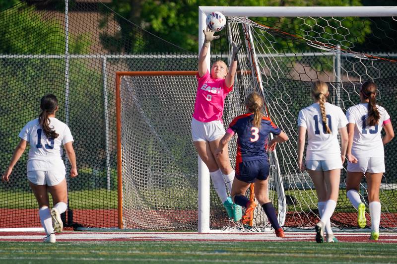 Oswego East's Madelynn McGregor (0) goes up high for a save against Oswego during a Class 3A Lockport Regional semifinal soccer match at Lockport High School in Lockport on Wednesday, May 15, 2024.