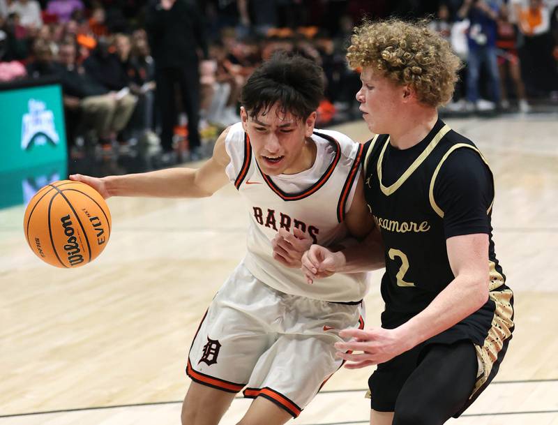 DeKalb's Aaron Ziga tries to drive by Sycamore's Logan Hodges Friday, Jan. 30, 2026, during the FNBO Challenge at the Convocation Center at Northern Illinois University in DeKalb.