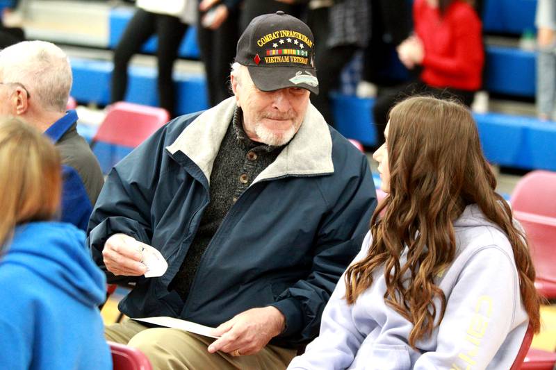 Thompson Middle School eighth grader Emma Campagna chats with her grandfather, Herb Moll of St. Charles, during a ceremony honoring veterans at the St. Charles school on Friday, Nov. 10, 2023.