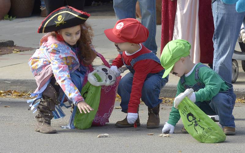 Children rush to grab up the candy treats thrown their way Saturday during Ottawa’s Halloween Parade.