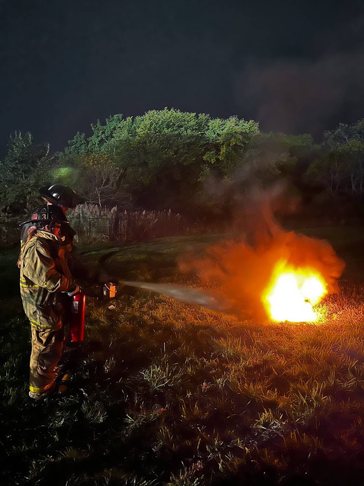 Joliet Fire Department Apparatus Operator John Moiser (back) instructs 
Brianna Sing on how to properly select and use a fire extinguisher during the Joliet Fire Department Citizen Fire Academy.