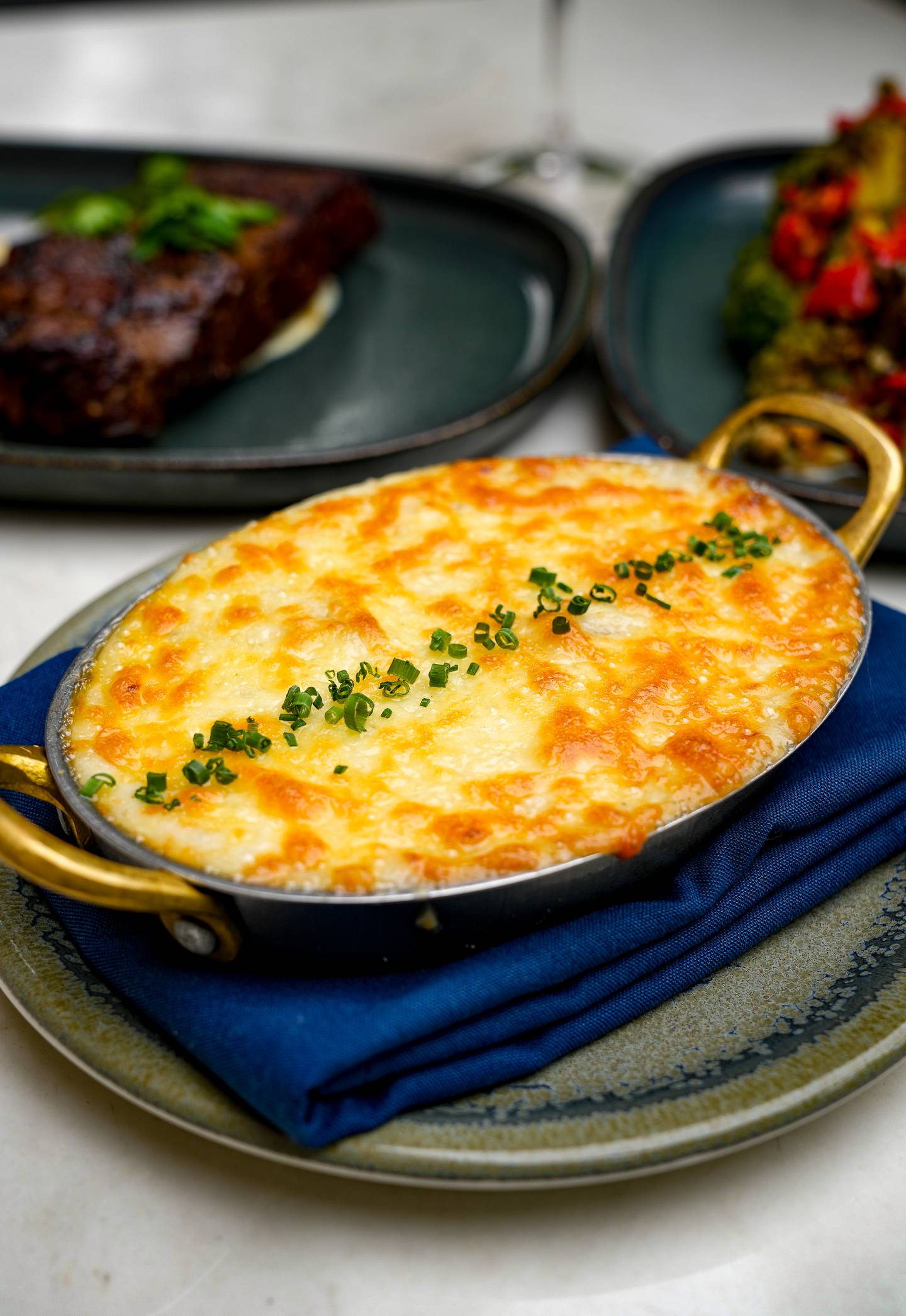 Truffle Potato Gratin is an appetizer of thinly sliced potatoes layered in a creamy, truffle-infused sauce, baked to a golden, crispy finish.