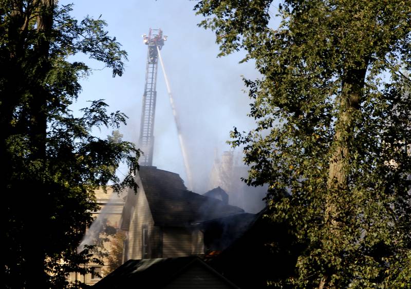 Firefighters battle a house fire in the 300 block of Lincoln Avenue in Woodstock Monday, Oct. 9, 2023, after an explosion following suspected gas leak in the area.