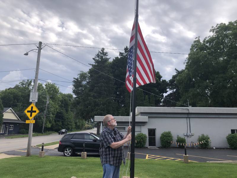 Donald Huebner of Woodstock adjusts an upside-down flag flying outside his home on June 4, 2024. Someone stole another flipped flag from his pole, he said.