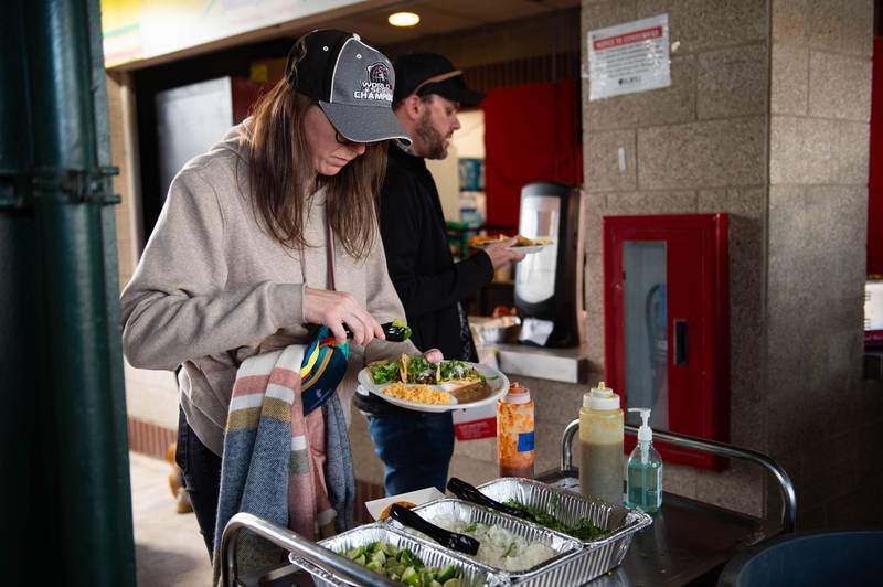 Anna Nickleski makes additions to her taco from Sunshine Mexican Cafe during the Joliet Slammers home opener Friday May 10, 2024 at Duly Health and Care Field in Joliet