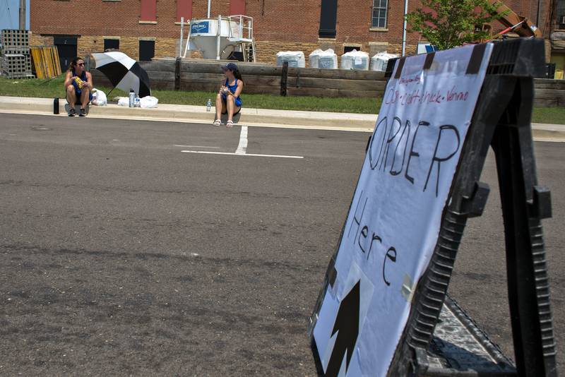 Crystal Killian (left) and Emilie Barton work the order lane Monday afternoon at the at the Sterling Marketplace for the Broil and Boil fundraiser.