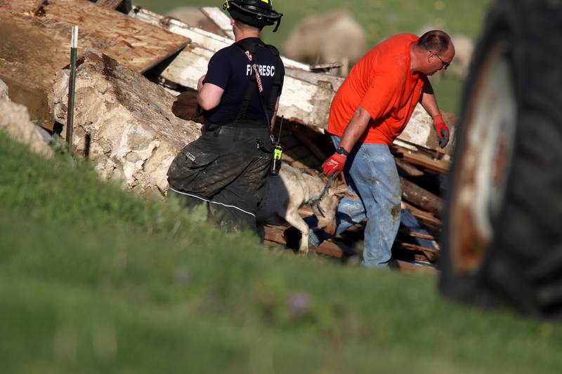 First responders and property owners tend the scene of a barn collapse along Weidner Road near Harvard on Tuesday evening.