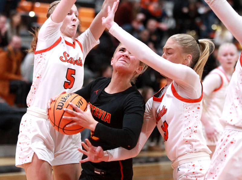 Batavia’s Samantha Jansey looks for an opening between St. Charles East defenders Brooklyn Schilb (left) and Alyse Price (right) during a game on Wednesday, Jan. 8, 2025 in St. Charles.