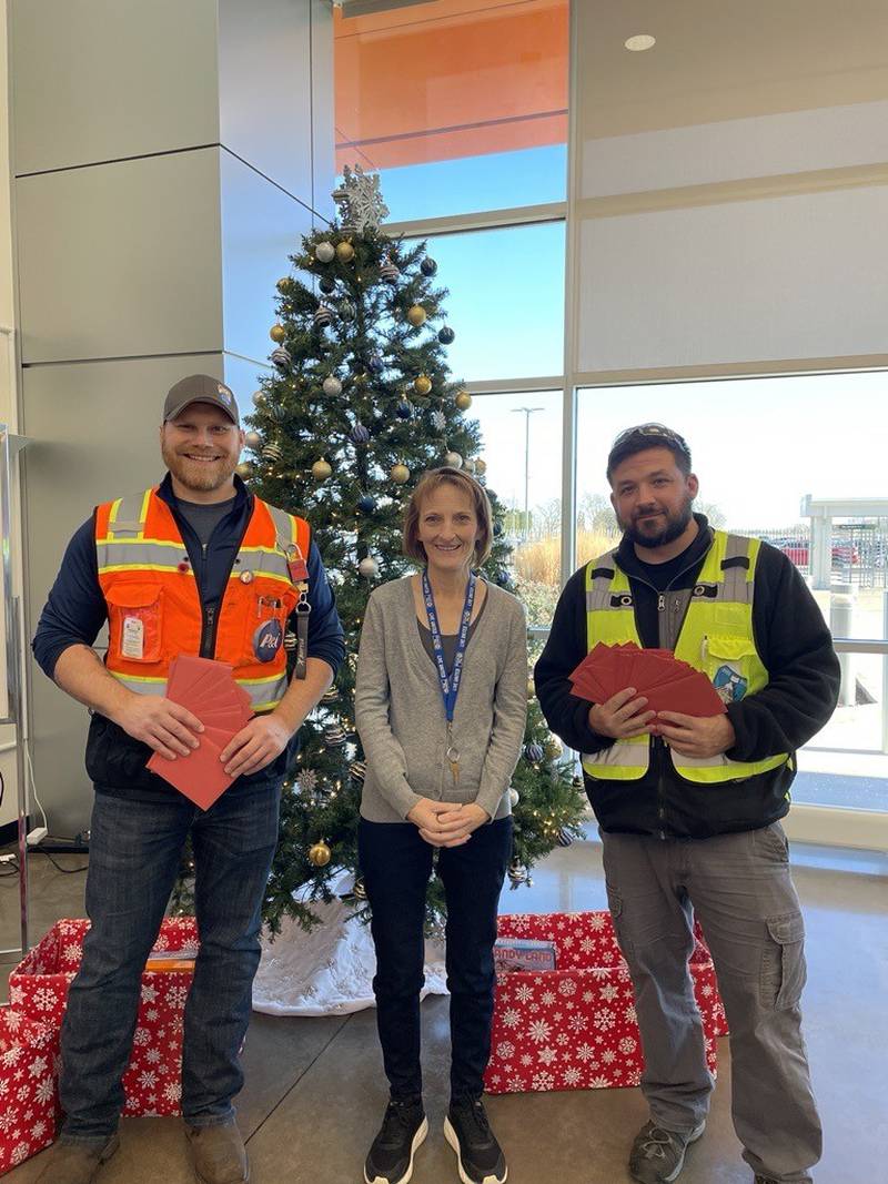 Karen Nall (center) with two Procter and Gamble workers, who are distributing holiday cards to local veterans.