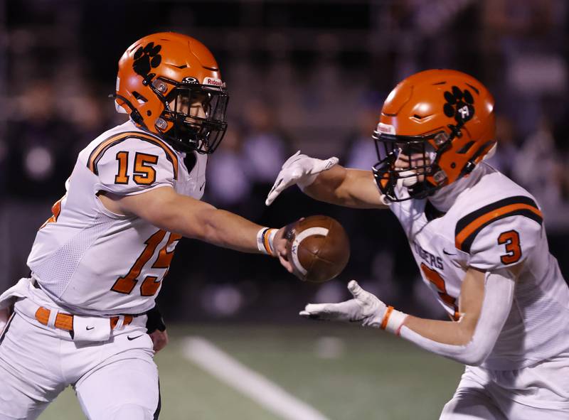 Wheaton Warrenville South's Luca Carbonaro (15) hands off the ball to Owen Yorke (3) during the 7A first-round playoff game between Wheaton Warrenville South and Downers Grove North high schools on Friday, Nov. 1, 2024 in Downers Grove.