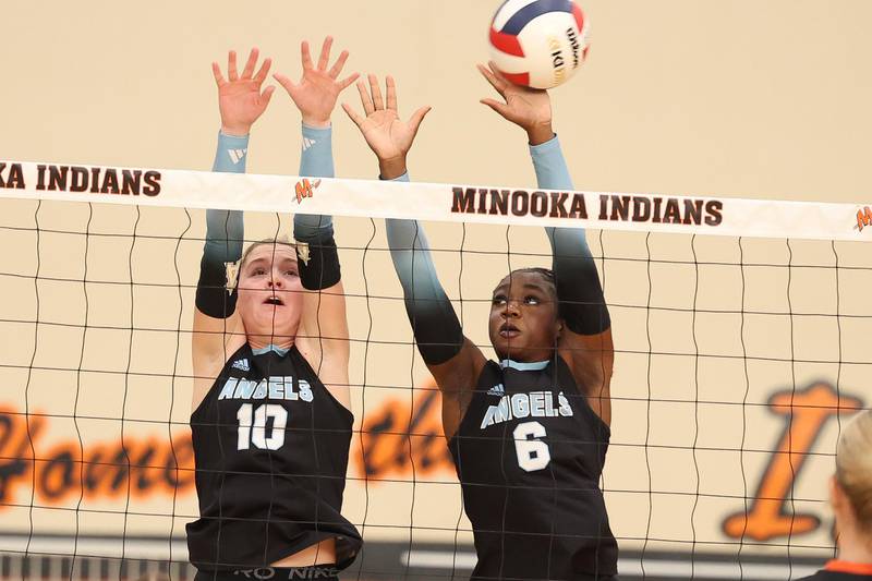 Joliet Catholic’s Olivia Emerson, left, and Heavenly Sorfo go for the block against Minooka on Wednesday, Sept. 4, 2024 in Minooka.