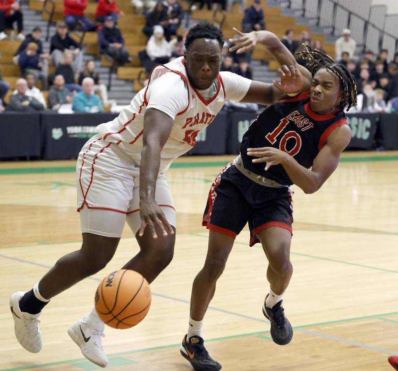 Palatine's forward Tony Balanganayi (50) fouls Glenbard East's Cameron Bonner (10) as he goes for a loose ball during the 51st Jack Tosh Holiday Classic basketball tournament Monday, Dec. 29, 2025 at York High School in Elmhurst.