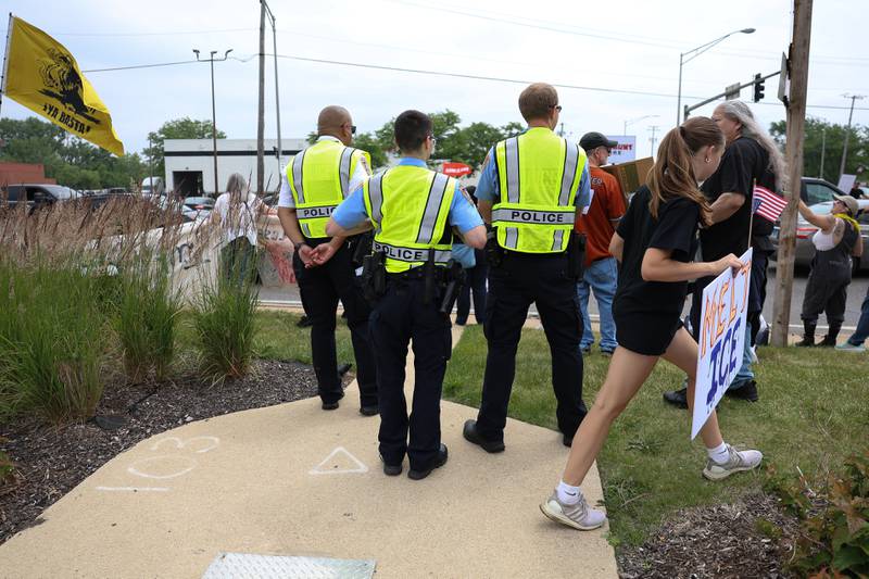 Joliet police stand near the intersection of North Larkin Avenue and West Jefferson Street during the No Kings Day protest on Saturday, June 14, 2025 in Joliet. The event was considered calm with no problems.