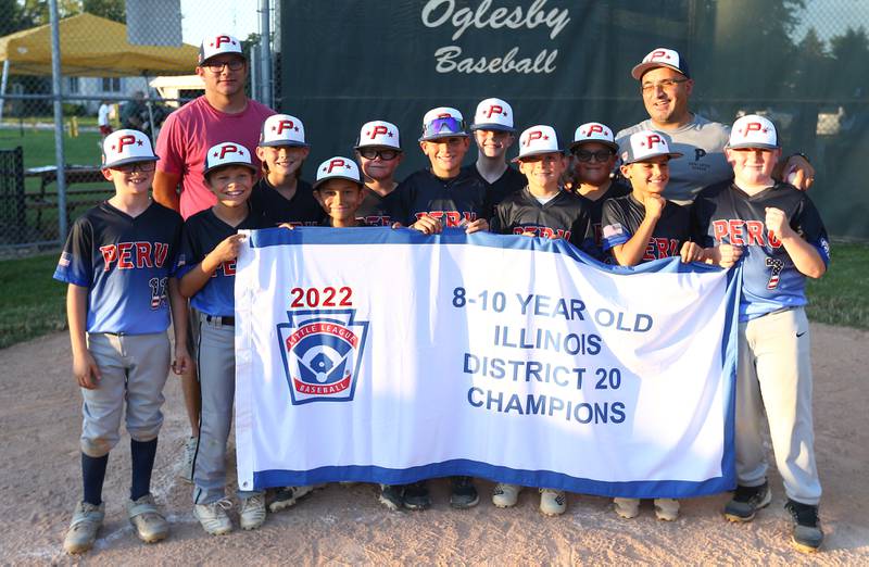 Members of the Peru All-Stars hold the 8-10 year old District 20 Little League championship banner after defeating Streator's All-Stars on Wednesday, July 13, 2022, at Jim Bottomley Field in Oglesby.