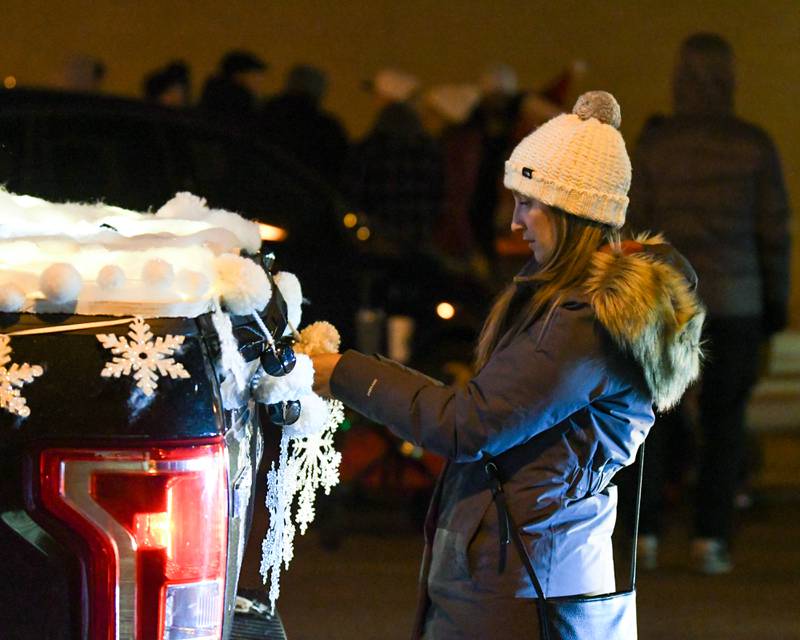 Ellen Giuntoli of Glen Ellen decorates the truck that played music for the dancers from the non for profit Front Street Dance Center before the start of the Wheaton Holiday Parade held on Friday Nov. 23, 2023.
