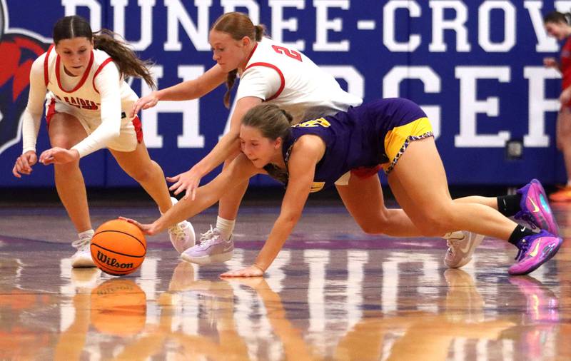 Huntley’s Evelyn Freundt, left, and Avery Suess, center, race Hononegah’s Addison Beilfuss for the ball in girls basketball at Dundee-Crown High School in Carpentersville on Tuesday, November 25, 2025.